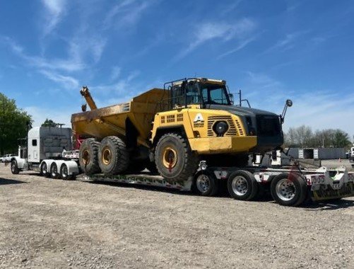 Articulated dump truck loaded and secured on an AJC Heavy Hauling lowboy trailer