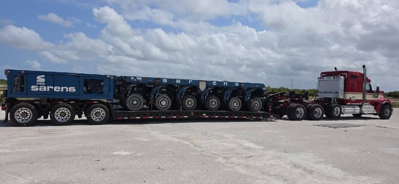AJC tractor pulling a Sarens self-propelled module on a multi-axle trailer